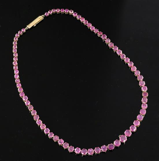 A gold and graduated round cut ruby line necklace, 40cm